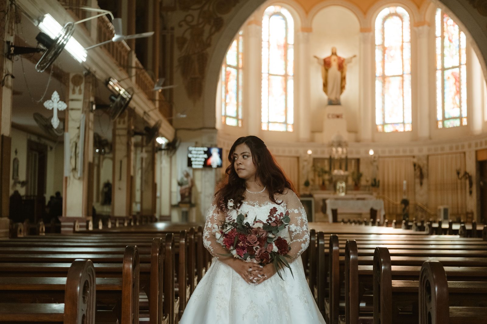Bride holding her bouquet in the church aisle